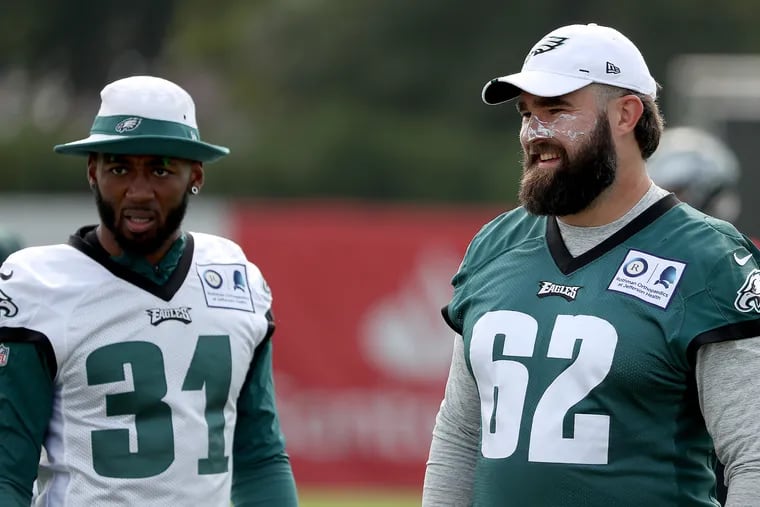 Jalen Mills, left, talks with Jason Kelce, who was wearing extra sunscreen, during Eagles training camp Wednesday.