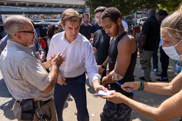 Mehmet Oz is handed paper by Jessica Ohm for an autograph during his visit last month to McPherson Square Park in Kensington.
