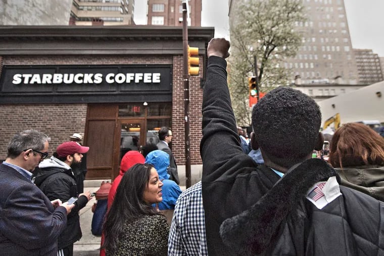 Christopher Potts (right) protests outside the Starbucks on 18th &amp; Spruce Streets on Monday.