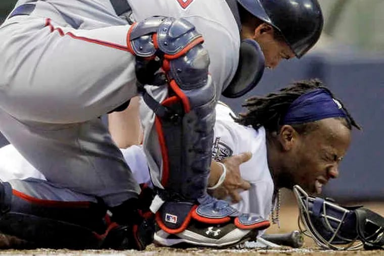 Nationals catcher Ivan Rodriguez bends over Milwaukee's Rickie Weeks after the Brewer was beaned on Saturday night.