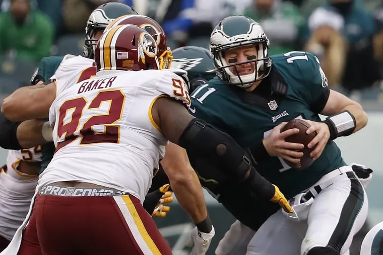 Carson Wentz takes a hit against Washington in a December game. The Eagles and Redskins will play in a season opener this year.