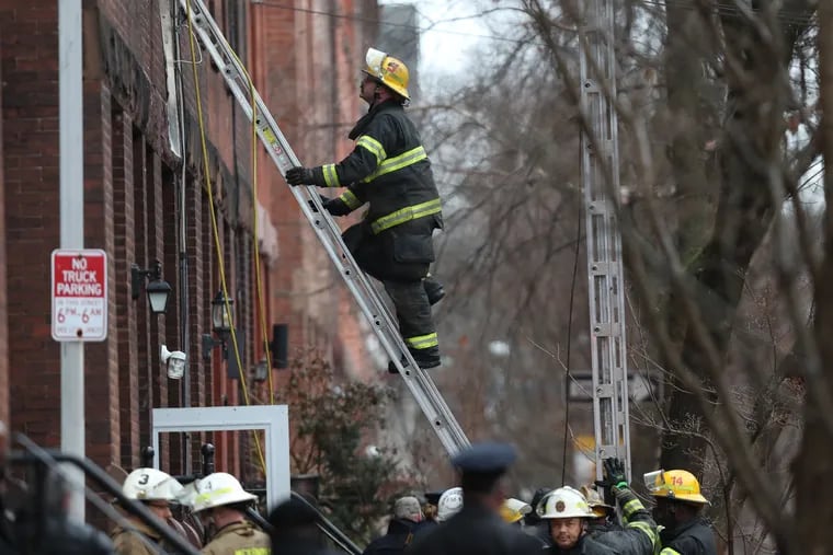 A firefighter works at the scene of a fire on the 800 block of North 23rd Street in Philadelphia on Wednesday, Jan. 5, 2022.