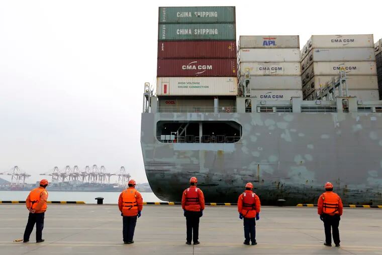 Workers watch a container ship arrive at a port in Qingdao in east China's Shandong province. China cut tariffs on $75 billion of U.S. imports including auto parts on Thursday, Feb. 6 in response to American reductions as part of their truce in a trade war.