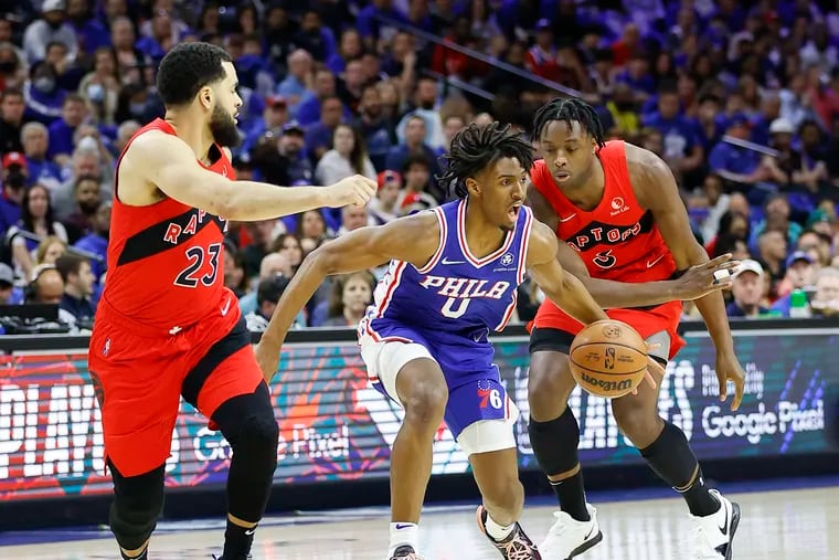 Sixers guard Tyrese Maxey dribbles the basketball against Toronto Raptors forward OG Anunoby (left) and guard Fred VanVleet in the first quarter during game one of the Eastern Conference quarterfinals on Saturday, April 16, 2022 in Philadelphia.  Embiid believed he was fouled on the play.