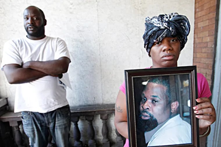 Troy Wimberley’s widow, Sabrina, holds a portrait of her husband. With her is the victim’s brother Ellick. ALEJANDRO A. ALVAREZ / Staff Photographer
