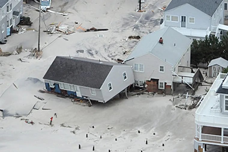 Hurricane Sandy's devastation shows in the Brandt Beach area on the southern end of Long Beach Island as a beach house is washed off its foundation on Tuesday. ( CLEM MURRAY / Staff Photographer )