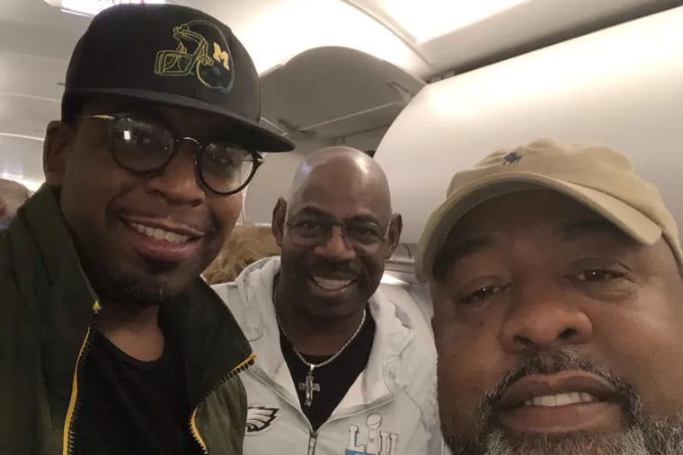 Pastor Herbert "Herb" Lusk, II (center) smiles with son The Rev. Herbert Lusk, III (left) and friend The Rev. Reginald Johnson, Sr. (right) aboard their flight to Fort Myers. In the air, Mr. Lusk led an emergency prayer, pushing for an Eagles win.