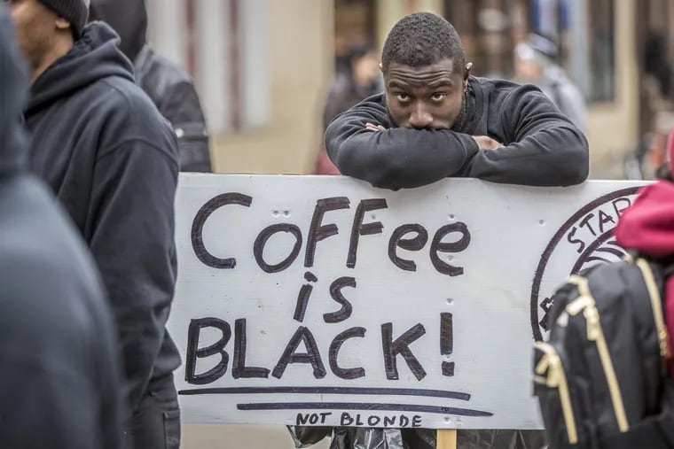 Jack Willis leans over his sign during a Black Lives Matter demonstration at the Starbucks at 18th and Spruce.
