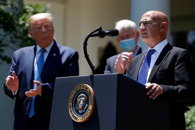 Then-President Donald Trump listens as Moncef Slaoui, a former GlaxoSmithKline executive, speaks about the coronavirus at White House event last year.