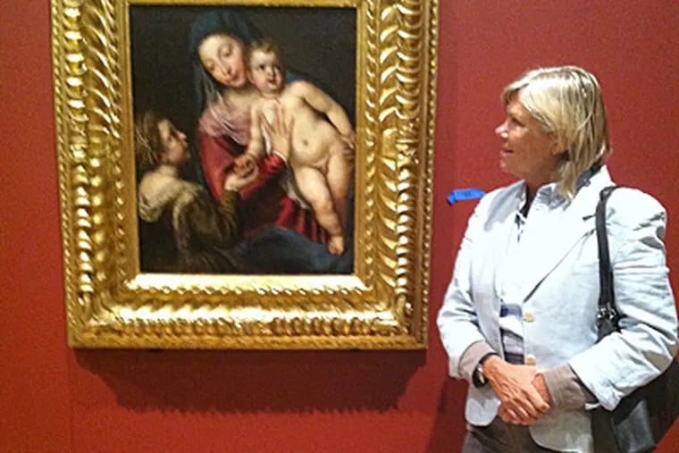 Linda Carioni, an organizer of the "Offering of the Angels" exhibit, points out "Mary with Child and Saint Catherine" by Tiziano. (Bill Reed / Staff)