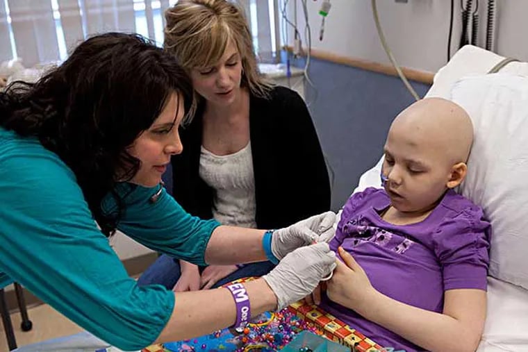 Emily Whitehead, 7, of Philipsburg, Pa., getting an infusion of the gene therapy from nurse Colleen Wallace as her mother, Kari, watches at Children’s Hospital in 2012. She was one of 22 children who participated in the study, and now the third grader takes gifts and encouragement to other children there.