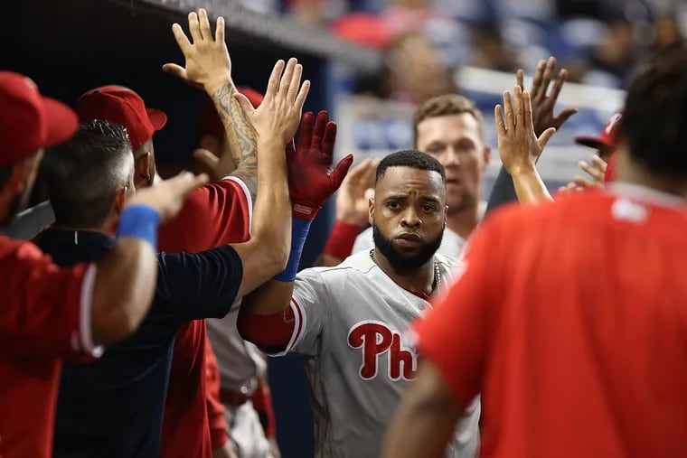 Phillies' first baseman Carlos Santana greets his teammates after scoring in the second inning against the Marlins on Tuesday.
