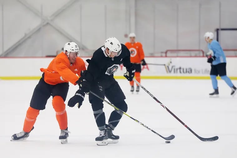 Phil Myers (right) battles Isaac Ratcliffe for the puck during the first day of Flyers rookie camp Saturday at the Skate Zone in Voorhees.