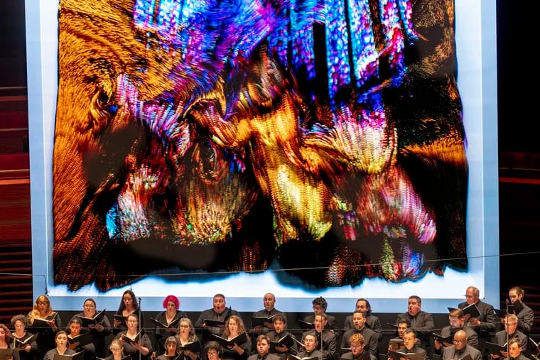 The Philadelphia Symphonic Choir sings under flowing computer images designed by artist Refik Anadol to produce a real-time installation using digital media, data, and artificial intelligence in response to the Philadelphia Orchestra performance of Beethoven's Missa Solemnis April 7 in Verizon Hall.