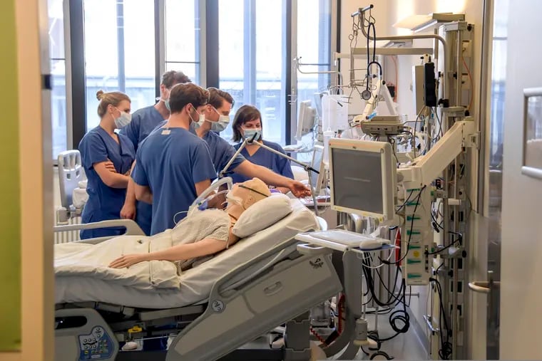 In this photo from Tuesday, hospital doctors get instructions on a ventilator at the University Hospital Eppendorf in Hamburg Germany.