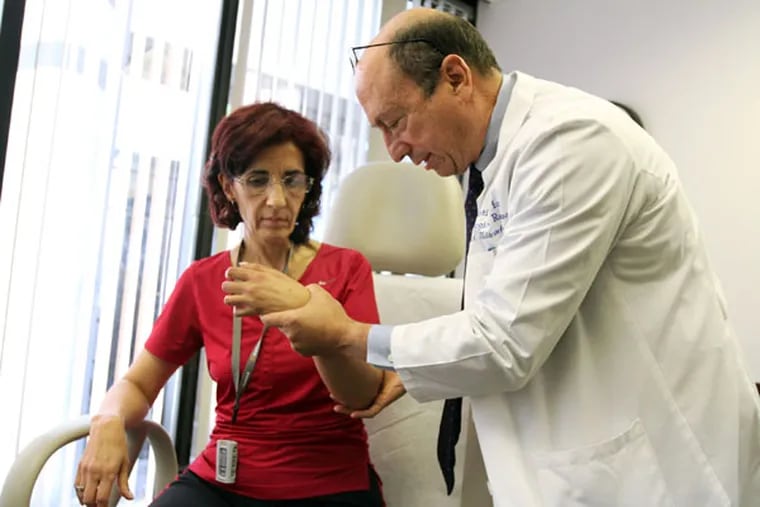 Dr. Edward Tobinick checks Anna Alfaro for mobility during a treatment aimed at helping brain injury patients recover movment event years after stroke or other injury. The treatment is being given in Boca Raton, Florida, on December 3, 2012. (Carline Jean/Sun Sentinel/MCT)