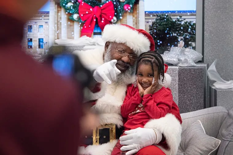 Tehilah Chambers, 4, of Philadelphia, poses for a portrait with Santa (David Hendrix) at the Fashion District in Philadelphia on Sunday, Dec. 1, 2019.