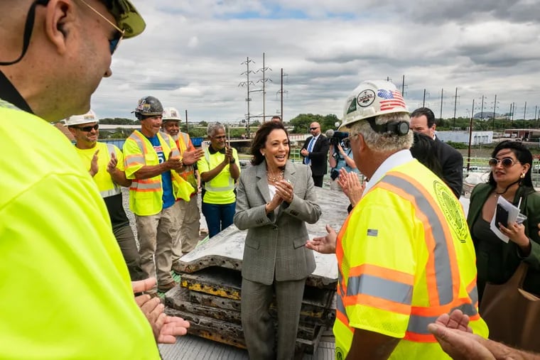 Vice President Kamala Harris (center) applauds workers during a visit to a construction site on I-95 in Philadelphia last year. Harris will return to the city Monday.