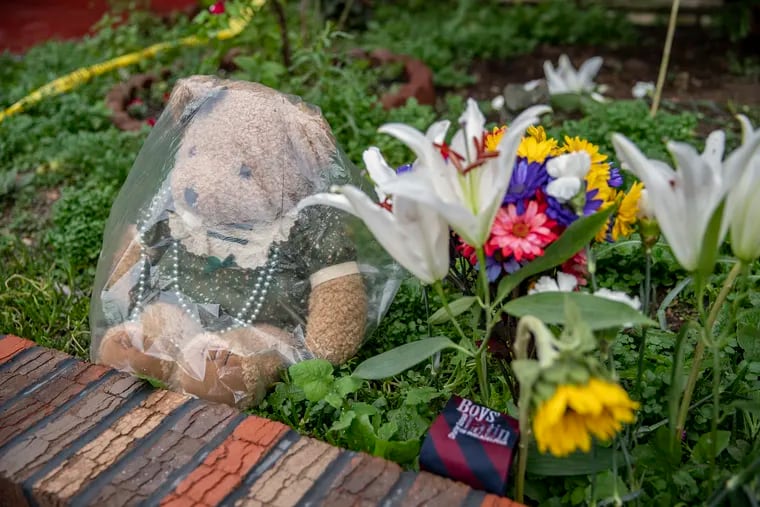 A Boys Latin tie sits next to flowers and a bear in front of the home on the 5000 block of Walton Avenue in West Philadelphia the day after a quadruple shooting there. Maurice Louis, 29, is charged with four counts of murder in the deaths of his mother, his stepfather, and two brothers, one of whom, Sy-eed Woodson, was a senior at Boys Latin. Classmates brought the tie and flowers, according to neighbors.