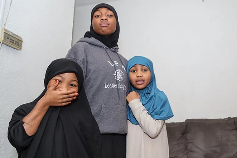 X'Aria Elliott, center, and her sisters, Sa'diyah Solomon, left, and Layla Solomon inside their Hunting Park home on Tuesday, Oct. 28, 2014.  X'Aria is one of the more than 200 seniors displaced by the abrupt closing of Palmer.  (Andrew Thayer / Staff Photographer)