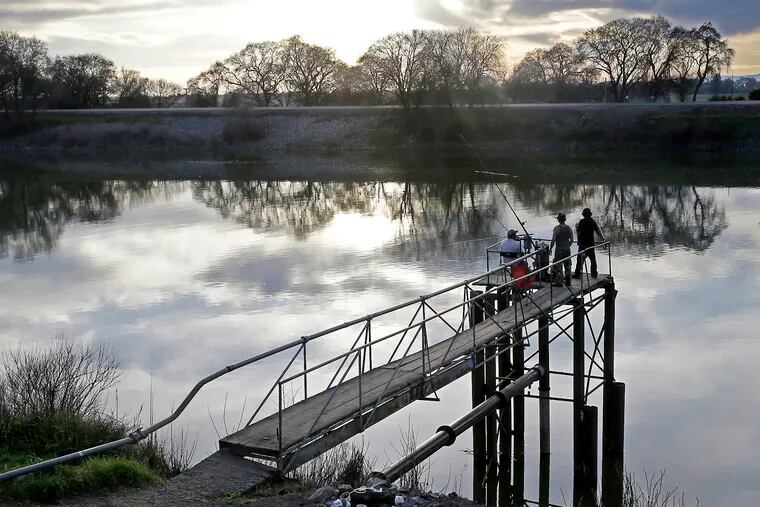 People try to catch fish along the Sacramento River in the San Joaquin-Sacramento River Delta, near Courtland, Calif.
