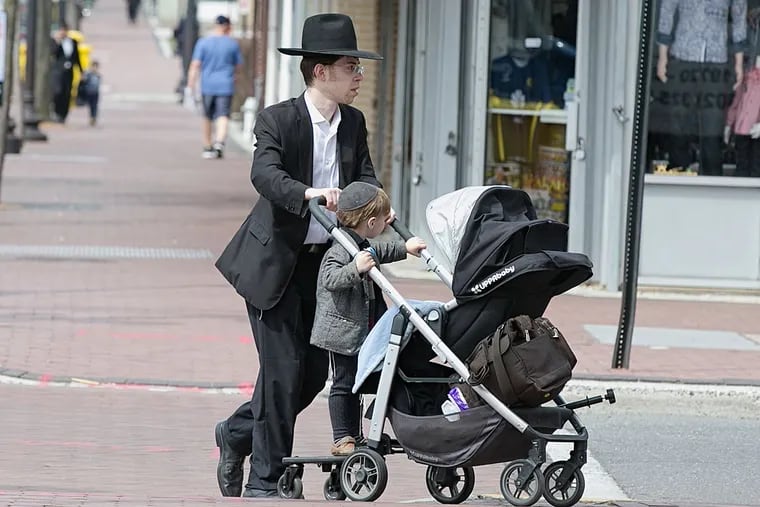 A Haredi Jewish man pushes a stroller down Clifton Avenue in Lakewood. Haredi Jews constitute more than 60 percent of the town’s population of 100,000.