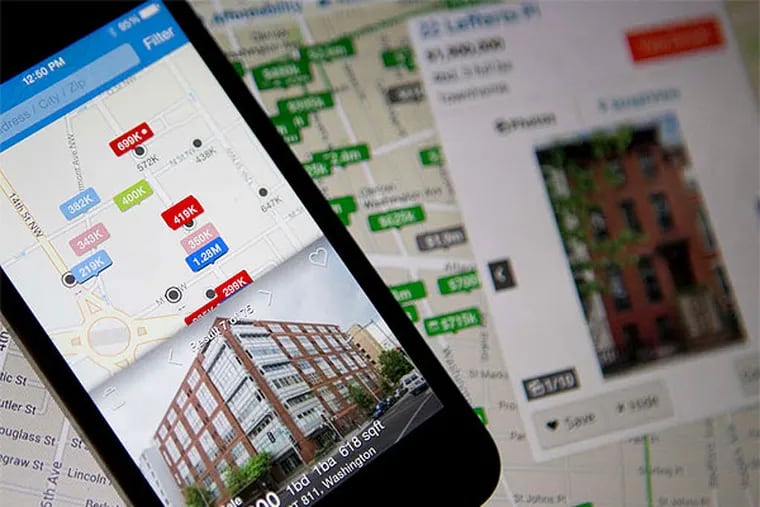 The Zillow Inc. real estate app on an iPhone, and the Trulia Inc. website on a screen. (Andrew Harrer / Bloomberg)