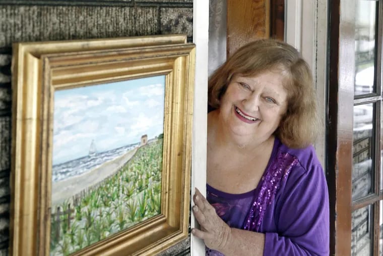 Mary Lou Adams , organizer of the annual Gloucester City Riverfront Music/Arts Festival, with one of her own artworks.