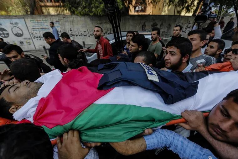 Mourners carry the body of Palestinian journalist Yasser Murtaja, who was killed during clashes with Israeli security forces, during his funeral in Gaza City on Saturday, April 7, 2018.