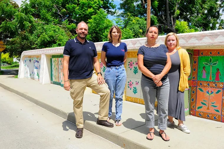 Tim Zatzariny Jr., Maureen Peters, Doris Nogueira-Rogers and Jacqualynn Knight, members of the FAF Coalition stand on the Hunter St. bridge in Woodbury, NJ. on Thursday, July 23, 2015. The four are trying to bring art festivals into the city as they have done in the past, but are now being halted by city officials' new regulations. (MICHAEL PRONZATO / Staff Photographer)