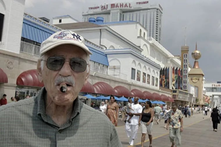 Cal Mazzo, 83, of Reading, Pa., takes a cigar break on the boardwalk after playing in an Atlantic City casino. (Akira Suwa / Inquirer)