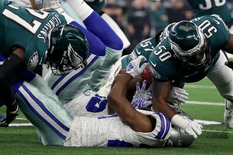 Dallas cornerback Jourdan Lewis appears to fumble the ball on the opening kickoff after getting hit by Malcolm Jenkins (left) and LaRoy Reynolds. The officials concluded the Eagles did not recover the fumble, although it appeared that way.
