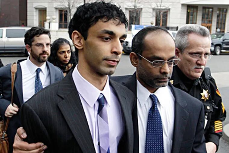 Dharun Ravi, (center) is helped by his father, Ravi Pazhani, as they leave court in New Brunswick, N.J. MEL EVANS / Associated Press