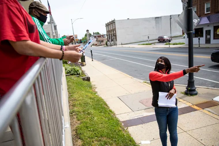 Ann Cunningham points Coatesville residents to a nearby vaccine site on Friday, May 7, 2021.