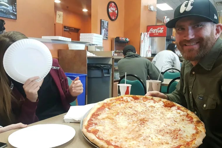 The author right with the first Sams Pizza pie of 2018 in February. His daughter, Remi, is behind the plate. Shes 13.