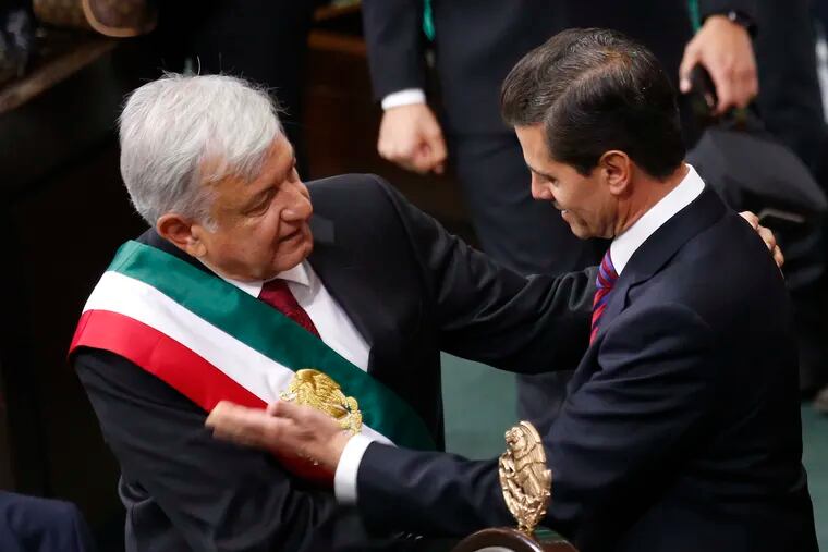 Mexico's new President Andres Manuel Lopez Obrador and outgoing President Enrique Pena Nieto embrace at the end of the swearing-in ceremony in the lower house chambers of the National Congress, in Mexico City, Saturday, Dec. 1, 2018. Lopez Obrador took the oath of office Saturday as Mexico's first leftist president in over 70 years, marking a turning point in one of the world's most radical experiments in opening markets and privatization. (AP Photo/Marco Ugarte)