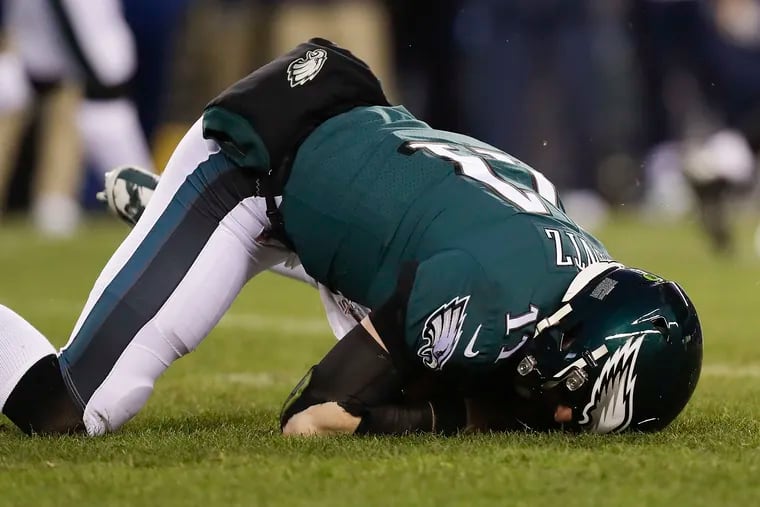 Eagles quarterback Carson Wentz falls on the turf after getting hit by Seattle Seahawks defensive end Jadeveon Clowney.