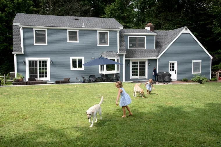 Charlotte McGowan, 6, (left) and her sister Eleanor play with the family's yellow labs in their Bucks County backyard in "a cute little neighborhood all on its own with a feeling of community, yet seclusion,” says their mom, Kirstin.