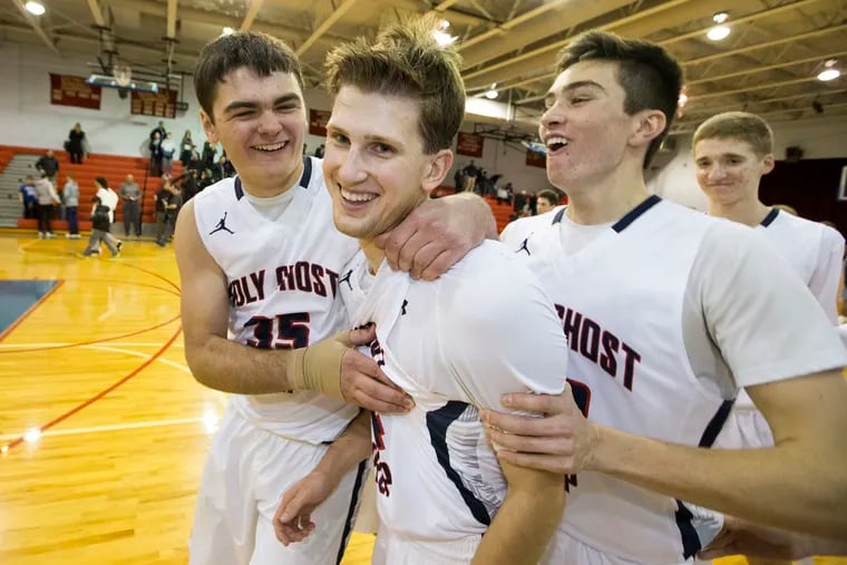 Jack Rittenmeyer, center, of Holy Ghost Prep is congratulated by Greg Calvin, left, and Greg Sylvester after hitting the winning shot in their 47-46 victory over Lower Moreland on Jan 16, 2018.