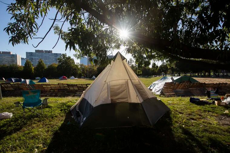 The sun breaks through the trees by part of the encampment on the Ben Franklin Parkway on Oct. 14, 2020. The encampment organizers reached an agreement with Philadelphia to leave.