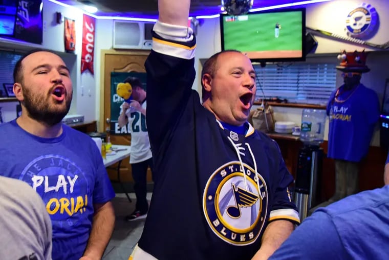 New St. Louis fans Mike Polidoro (right) in a Blues jersey he borrowed from his son Mike (left) celebrate the start St.Louis-San Jose game on Wednesday night.