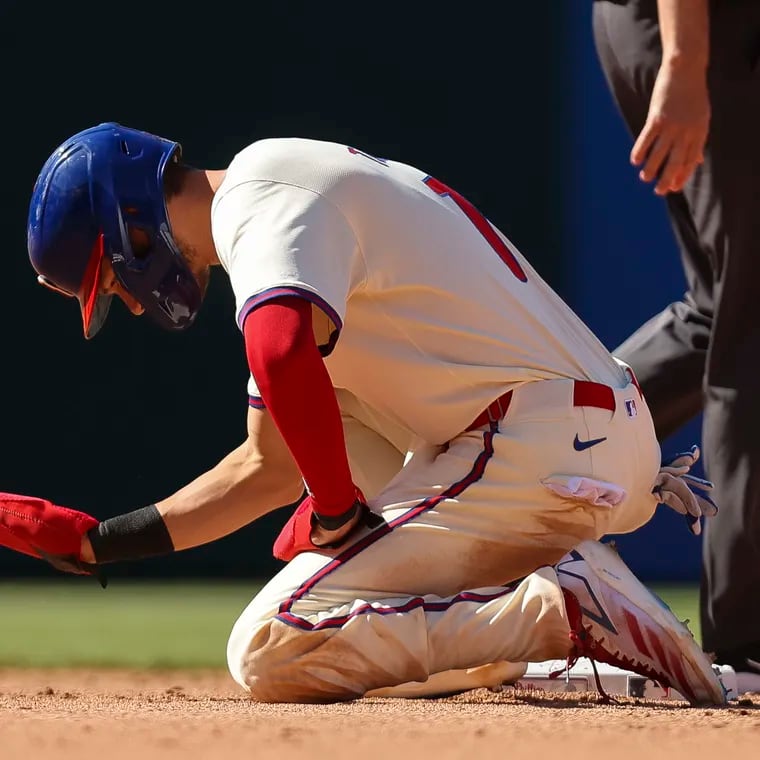 Philadelphia Phillies shortstop Trea Turner slaps the ground after a double play ends the eighth inning.