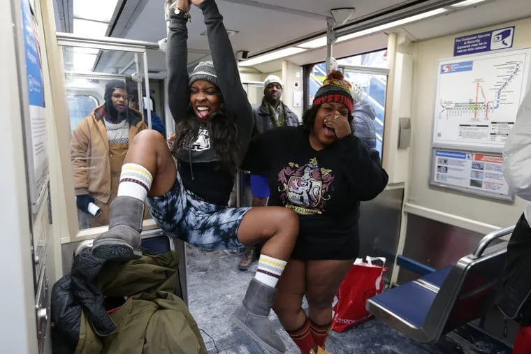 Leona Jenkins, left, and Denesha Williams, right, both of Norristown, joke around during the No Pants Subway Ride in Philadelphia on Sunday.