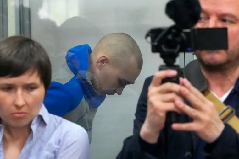 Russian army Sergeant Vadim Shishimarin, 21, is seen behind a glass during a court hearing in Kyiv, Ukraine, Friday, May 13, 2022. The trial of a Russian soldier accused of killing a Ukrainian civilian opened Friday, the first war crimes trial since Moscow's invasion of its neighbor.