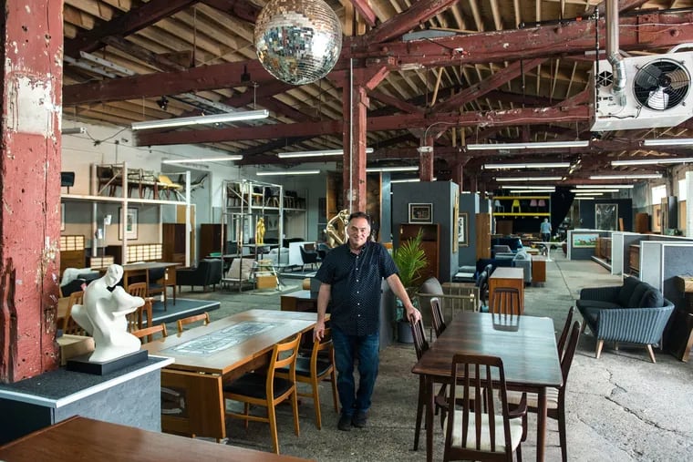 Mid-Century Furniture Warehouse owner Brian Lawlor stands inside his shop's display room in Port Richmond in 2019.