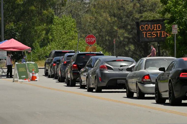 Cars line up for coronavirus testing at Hansen Dam Recreation Center, Tuesday, July 7, 2020, in Los Angeles. The resurgence of the virus has spiked demand in LA and across the state for tests, leading to long lines and a fear that supplies will run low and create a bottleneck in a system that has taken months to expand.
