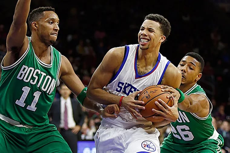 76ers point guard Michael Carter-Williams drives to the basket as the Celtics' Evan Turner and Phil Pressey defend. (Yong Kim/Staff Photographer)