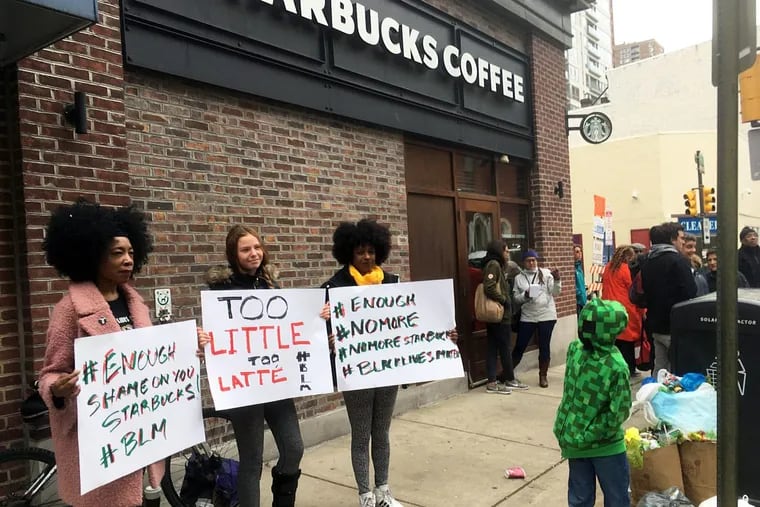 Demonstrators protest outside the Starbucks cafe in Philadelphia where two black men were arrested on April 12, 2018 for waiting inside without ordering anything.