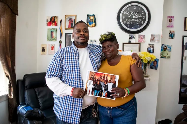 Rodney Herbert, 58, and his wife, Anita, 51, of North Philadelphia, hold a photo taken with seven of their 11 kids. The Father's Day Rally Committee will honor Rodney Herbert on Friday at its annual dinner.