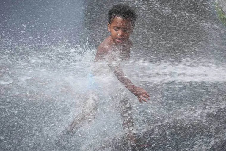 Two-year-old Camren Amtos plays in a fire hydrant along 4th Street in Feltonville with his stepfather (not pictured) on July 2, 2014. (RON TARVER / Staff Photographer)